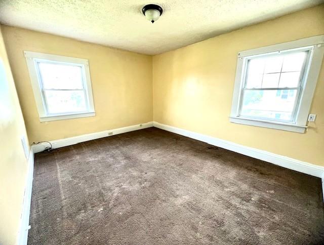 582 Spruce Ave, Sharon, PA 16146 - unfurnished room with plenty of natural light, dark colored carpet, a textured ceiling, and baseboards