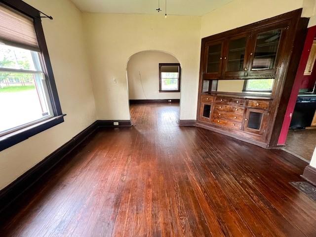 582 Spruce Ave, Sharon, PA 16146 - unfurnished living room with arched walkways, dark wood-style floors, and baseboards