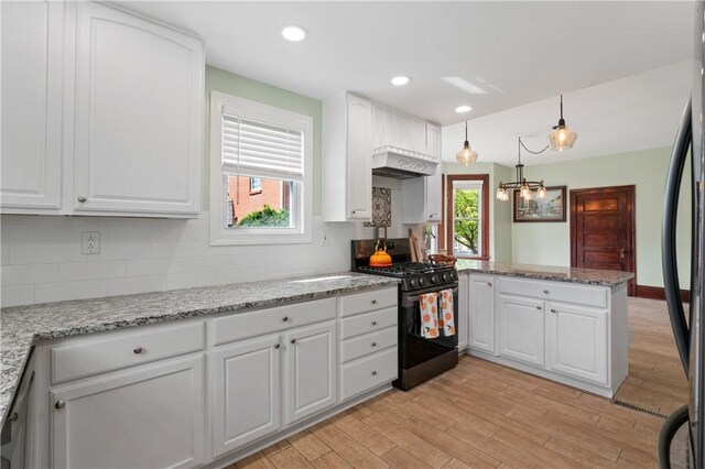 1622 Ridge Ave, Coraopolis, PA 15108 - kitchen featuring stainless steel range with gas stovetop, a peninsula, white cabinets, light wood finished floors, and tasteful backsplash