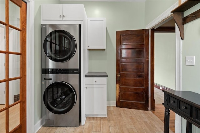 1622 Ridge Ave, Coraopolis, PA 15108 - laundry room with stacked washer / drying machine, cabinet space, light wood-type flooring, and baseboards