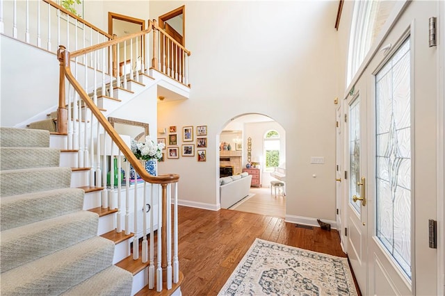 585 Agnes St, Hempfield Twp Wml, PA 15601 - entrance foyer with arched walkways, stairs, wood finished floors, a high ceiling, and baseboards