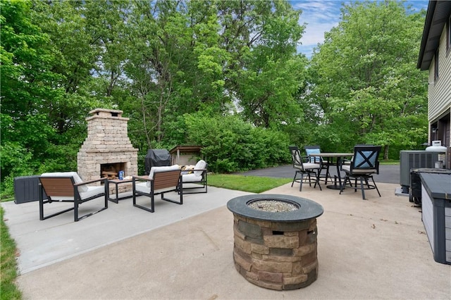 15 Fawnridge Dr, Robinson Twp Nwa, PA 15136 - view of patio featuring an outdoor stone fireplace, a fire pit, central air condition unit, and view of wooded area