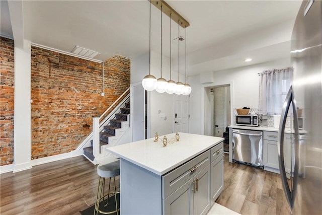 514 Knoll St, Central North Side, PA 15212 - kitchen with appliances with stainless steel finishes, gray cabinets, wood finished floors, light countertops, and brick wall