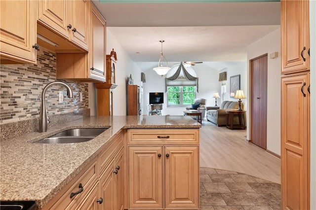 22 Ashford Dr, Cranberry Twp, PA 16066 - kitchen featuring a sink, open floor plan, a peninsula, tasteful backsplash, and light stone countertops