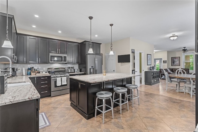 4232 Sherrod St, Lawrenceville, PA 15201 - kitchen with appliances with stainless steel finishes, a kitchen island, light stone countertops, a kitchen breakfast bar, and ceiling fan