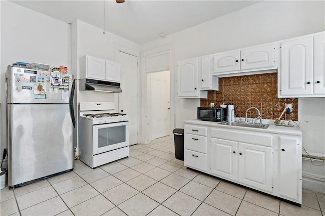 134 S 19th St, South Side, PA 15203 - kitchen with freestanding refrigerator, white gas stove, a sink, under cabinet range hood, and black microwave