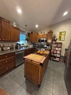 518 Equestrian Way, Mount Pleasant Twp Wml, PA 15666 - kitchen with stainless steel appliances, a kitchen island, light tile patterned flooring, recessed lighting, and brown cabinets