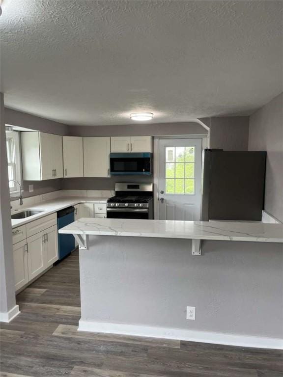 3309 Woodvue Dr, Whitehall, PA 15227 - kitchen with stainless steel gas stove, dishwasher, refrigerator, a sink, and a textured ceiling