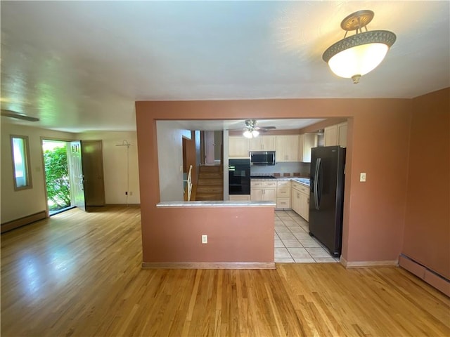 501 Kingsley Ave, Brentwood, PA 15227 - kitchen featuring black appliances, a baseboard radiator, a peninsula, and light wood-style floors