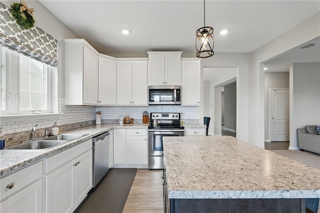3005 Sir Charles Dr, Cecil, PA 15057 - kitchen featuring appliances with stainless steel finishes, a sink, decorative backsplash, a center island, and light countertops