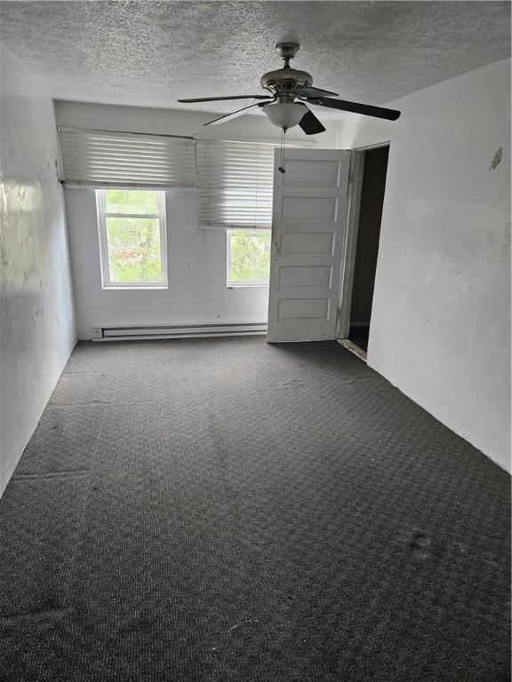 619 Dawson St, Wall Boro, PA 15148 - carpeted spare room featuring a baseboard heating unit, a ceiling fan, and a textured ceiling