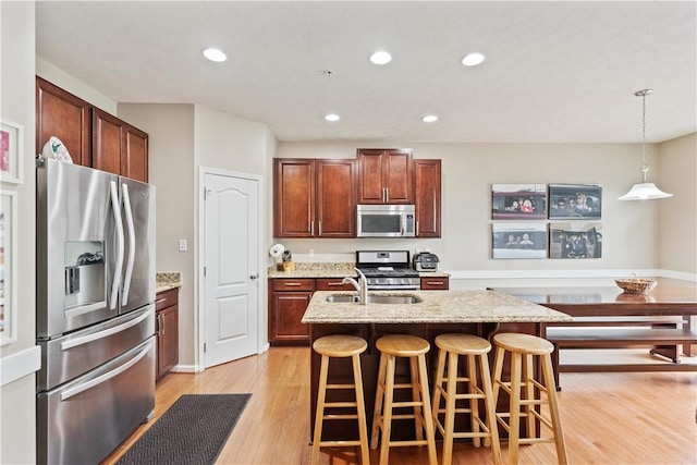 2282 Flint Dr, South Strabane, PA 15301 - kitchen with appliances with stainless steel finishes, light wood-type flooring, recessed lighting, an island with sink, and a breakfast bar area