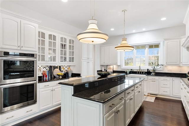 506 Villa Dr, Peters Twp, PA 15367 - kitchen featuring double oven, a center island, glass insert cabinets, white cabinets, and dark wood-type flooring