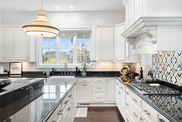 506 Villa Dr, Peters Twp, PA 15367 - kitchen with a sink, white cabinets, stainless steel gas cooktop, dark stone counters, and decorative light fixtures