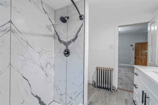 5 Rio Vista St, West Newton, PA 15089 - bathroom with radiator heating unit, a marble finish shower, vanity, wood finished floors, and baseboards