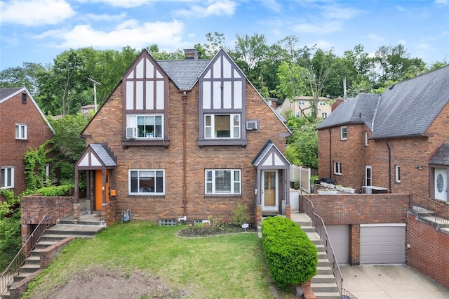 3983 Beechwood Blvd, Squirrel Hill, PA 15217 - tudor home with driveway, brick siding, a front lawn, and stairway