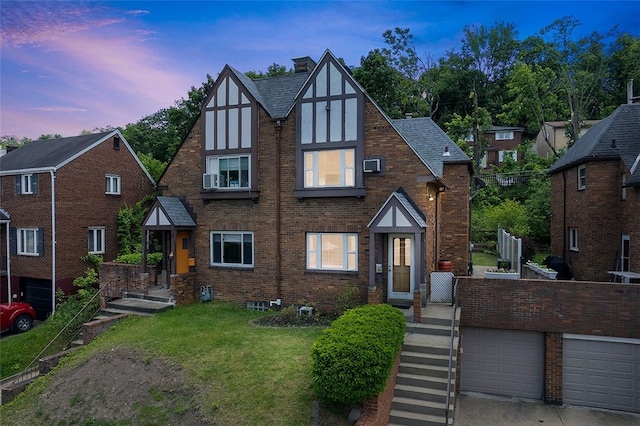 3983 Beechwood Blvd, Squirrel Hill, PA 15217 - tudor-style house with brick siding, a front yard, a chimney, and a garage