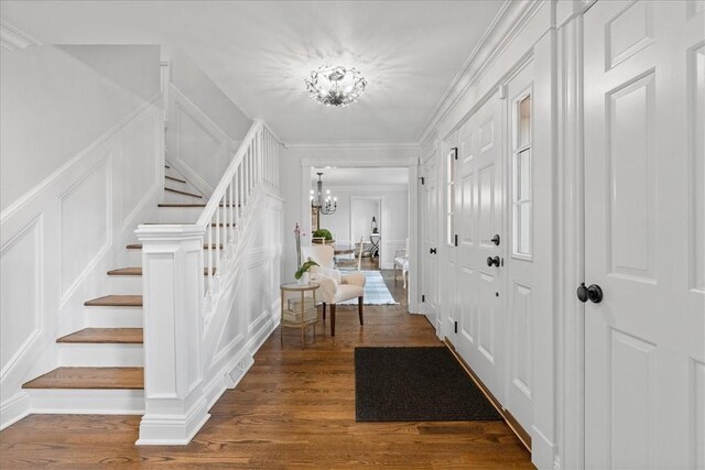 22 Woodland Rd, Edgeworth, PA 15143 - foyer with a decorative wall, a chandelier, stairway, dark wood-style floors, and ornamental molding