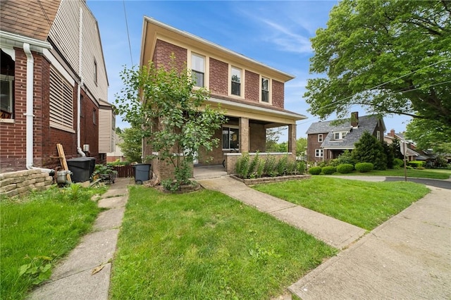 121 N Lehigh St, Munhall, PA 15120 - view of front of property with brick siding, covered porch, a front yard, and central AC