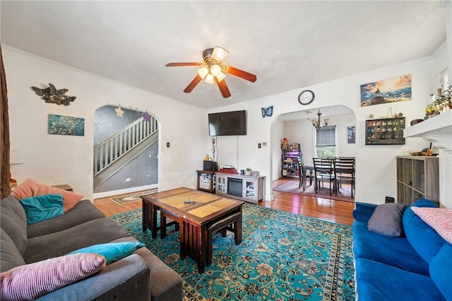 121 N Lehigh St, Munhall, PA 15120 - living area featuring arched walkways, a ceiling fan, wood finished floors, stairs, and crown molding