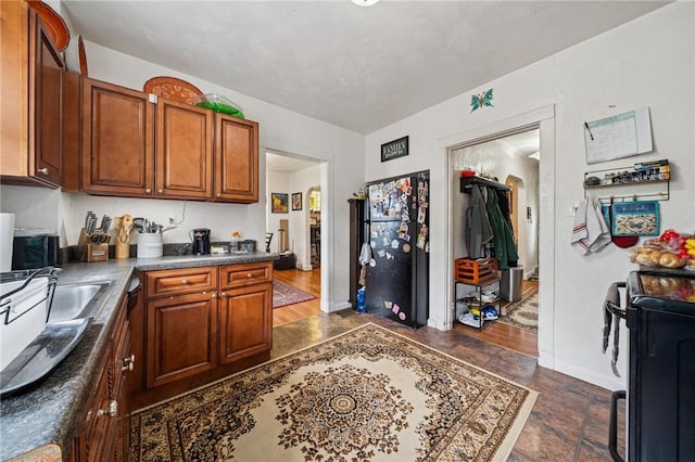 121 N Lehigh St, Munhall, PA 15120 - kitchen featuring stove, brown cabinetry, baseboards, and dark countertops