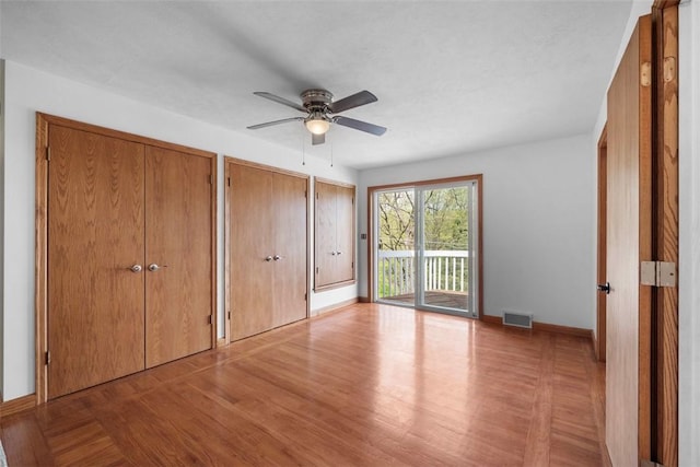 146 Peters Ln, Winfield Twp, PA 16023 - unfurnished bedroom with access to outside, multiple closets, wood finished floors, baseboards, and a ceiling fan
