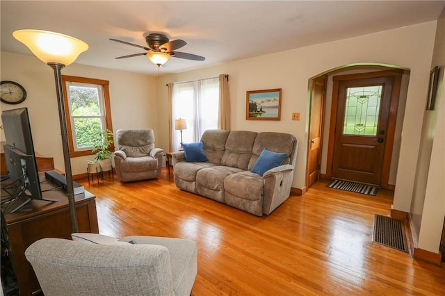 1265 Slippery Rock Rd, Liberty Twp, PA 16057 - living room featuring arched walkways, light wood-style floors, a ceiling fan, and baseboards