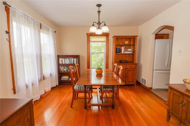 1265 Slippery Rock Rd, Liberty Twp, PA 16057 - dining area with arched walkways, light wood-style flooring, and a chandelier