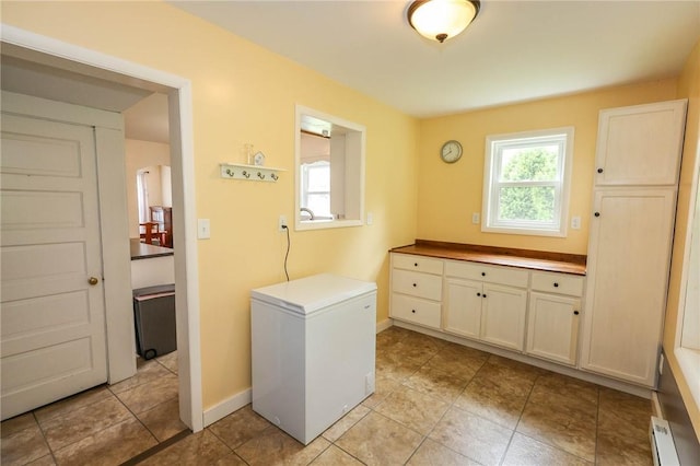 1265 Slippery Rock Rd, Liberty Twp, PA 16057 - laundry area with healthy amount of natural light, a baseboard radiator, baseboards, and light tile patterned floors