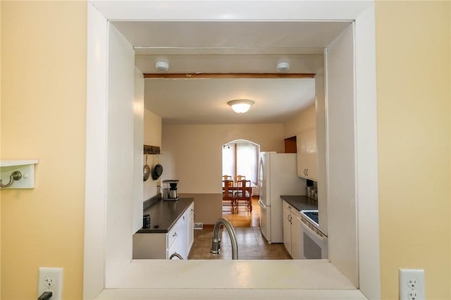 1265 Slippery Rock Rd, Liberty Twp, PA 16057 - kitchen featuring white appliances, dark countertops, a sink, tile patterned flooring, and arched walkways