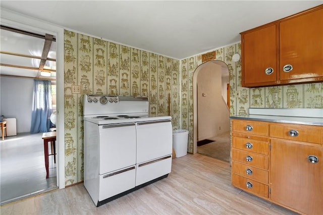 2265 State Route 982, Mount Pleasant Twp Wml, PA 15666 - kitchen featuring white range with electric cooktop, wallpapered walls, arched walkways, light wood finished floors, and brown cabinetry