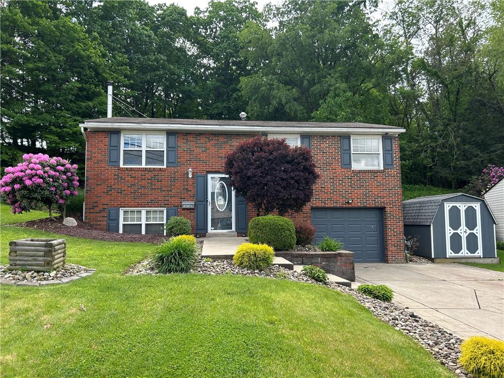 4965 Havana Dr, Plum Boro, PA 15239 - raised ranch featuring concrete driveway, a garage, a front lawn, and brick siding