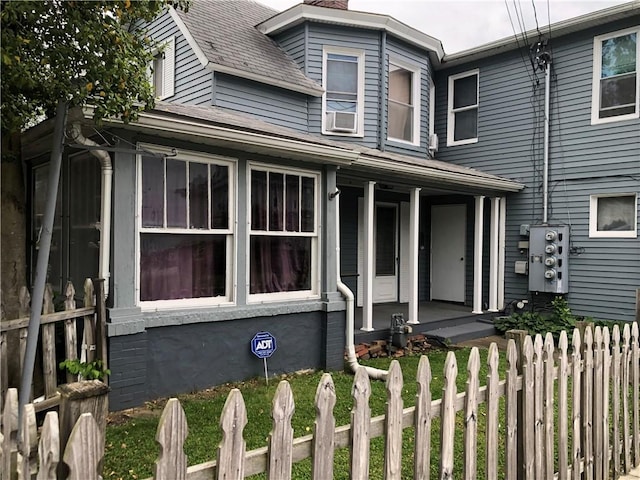 1 S Main St, Fairchance, PA 15437 - view of front facade featuring a porch, a fenced front yard, a chimney, and a shingled roof