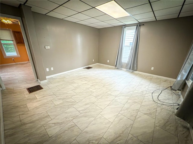 126 W Boyd Ave, City Of But Se, PA 16001 - spare room featuring healthy amount of natural light, a paneled ceiling, light marble finish flooring, and baseboards