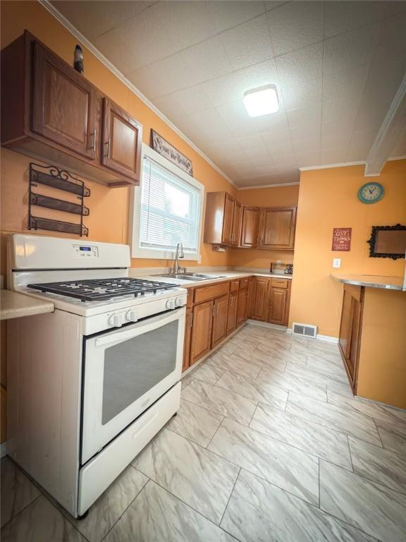 126 W Boyd Ave, City Of But Se, PA 16001 - kitchen featuring white gas range oven, a sink, ornamental molding, light marble finish flooring, and light countertops