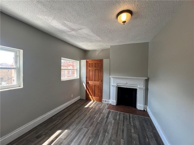 167 S 15th St, South Side, PA 15203 - unfurnished living room featuring a textured ceiling, dark wood-style floors, baseboards, and a fireplace