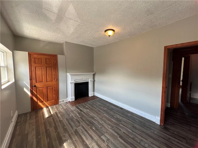 167 S 15th St, South Side, PA 15203 - unfurnished living room featuring dark wood-style flooring, a textured ceiling, baseboards, and a fireplace