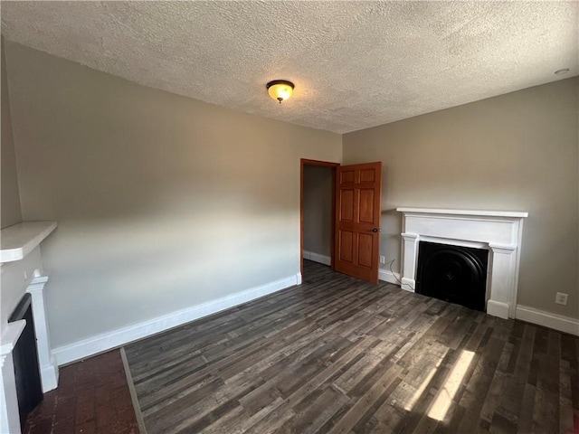 167 S 15th St, South Side, PA 15203 - unfurnished living room featuring a fireplace, a textured ceiling, baseboards, and dark wood-type flooring