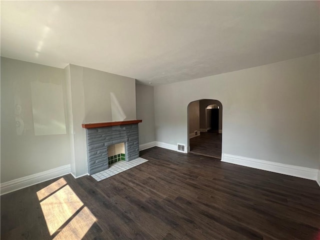 167 S 15th St, South Side, PA 15203 - unfurnished living room with dark wood-style flooring, arched walkways, baseboards, and a fireplace