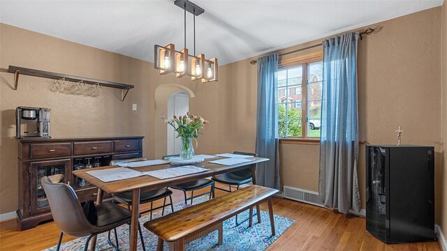 4720 Rolling Hills Rd, Whitehall, PA 15236 - dining space featuring light wood-style flooring, a chandelier, arched walkways, and baseboards