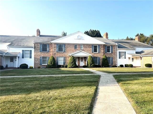 286 Windsor Rdg Unit 26, Neshannock Twp, PA 16105 - view of front facade featuring a front lawn, a chimney, and brick siding