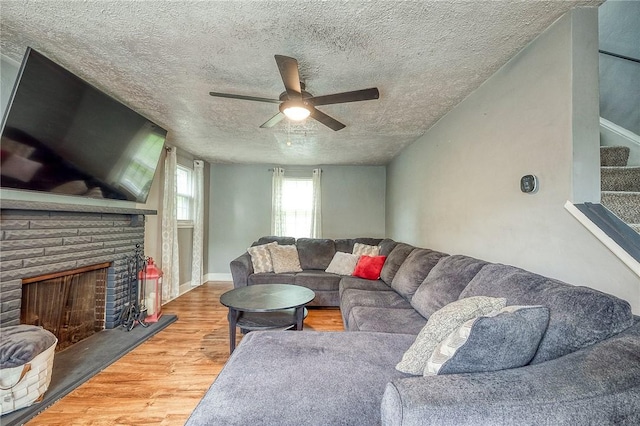 216 Siebert, Ross Twp, PA 15237 - living area with wood finished floors, a textured ceiling, stairs, a ceiling fan, and a fireplace with raised hearth