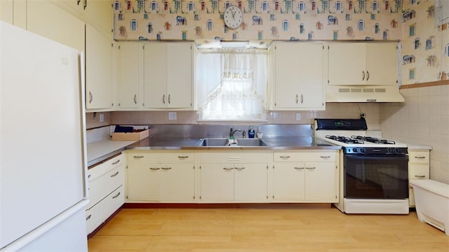 2120 Delaware Ave, Swissvale, PA 15218 - kitchen featuring stainless steel countertops, freestanding refrigerator, range with gas cooktop, exhaust hood, and a sink