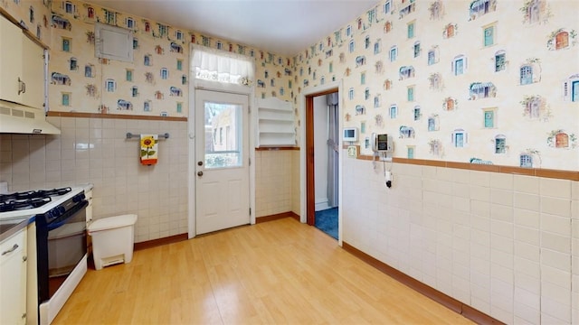 2120 Delaware Ave, Swissvale, PA 15218 - kitchen featuring range with gas cooktop, tile walls, wallpapered walls, under cabinet range hood, and wainscoting
