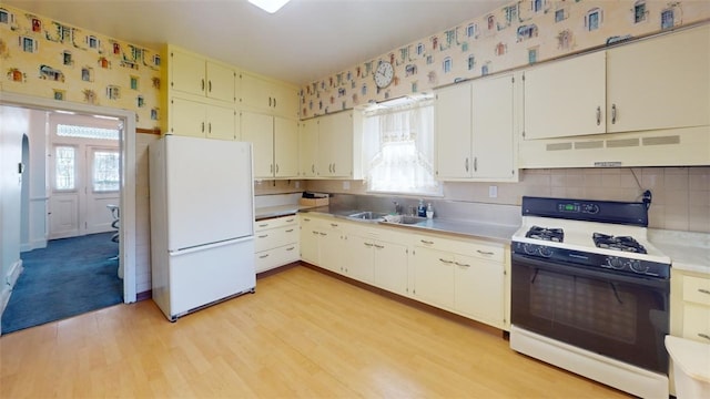 2120 Delaware Ave, Swissvale, PA 15218 - kitchen featuring range with gas cooktop, freestanding refrigerator, under cabinet range hood, healthy amount of natural light, and wallpapered walls