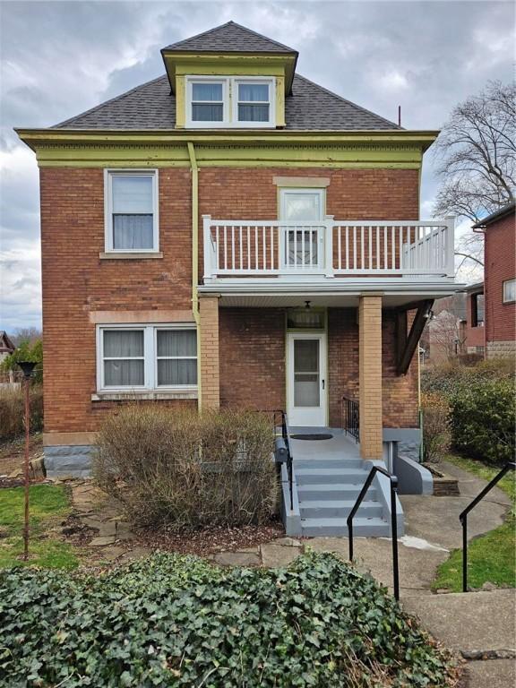 2120 Delaware Ave, Swissvale, PA 15218 - back of property featuring a balcony, brick siding, and roof with shingles