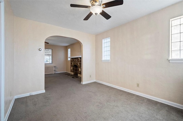 2238 Lucina Ave, Overbrook, PA 15210 - carpeted empty room featuring arched walkways, baseboards, ceiling fan, and a fireplace