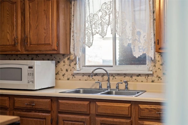 2238 Lucina Ave, Overbrook, PA 15210 - kitchen featuring white microwave, a sink, brown cabinets, and light countertops