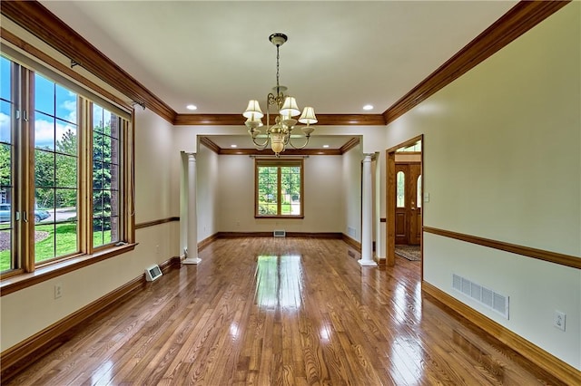 133 Ridgemont Dr, Cranberry Twp, PA 16066 - unfurnished dining area featuring a chandelier, crown molding, hardwood / wood-style floors, decorative columns, and baseboards