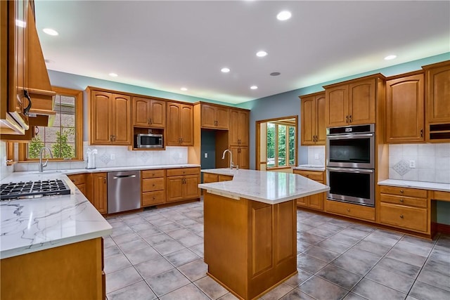 133 Ridgemont Dr, Cranberry Twp, PA 16066 - kitchen with appliances with stainless steel finishes, decorative backsplash, recessed lighting, light stone counters, and a center island with sink
